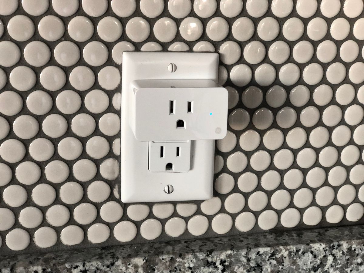 A smart plug installed in a wall outlet