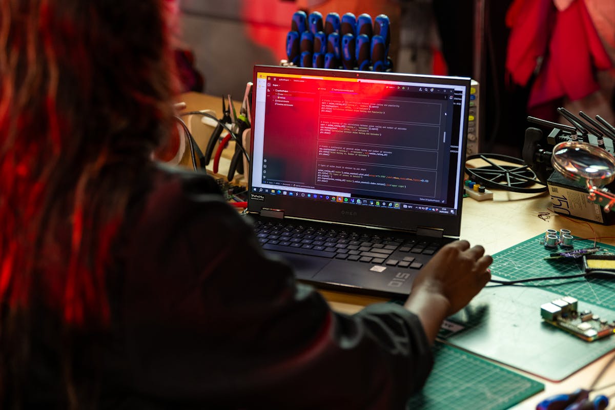 Close-up of a firmware engineer testing a connected device on a workbench