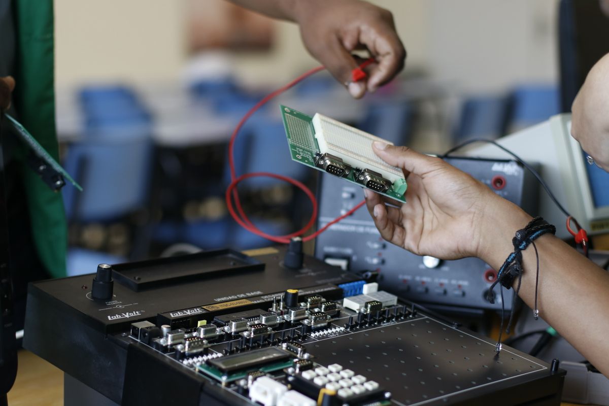 Engineer working with real hardware on a connected product test device in an electronics lab