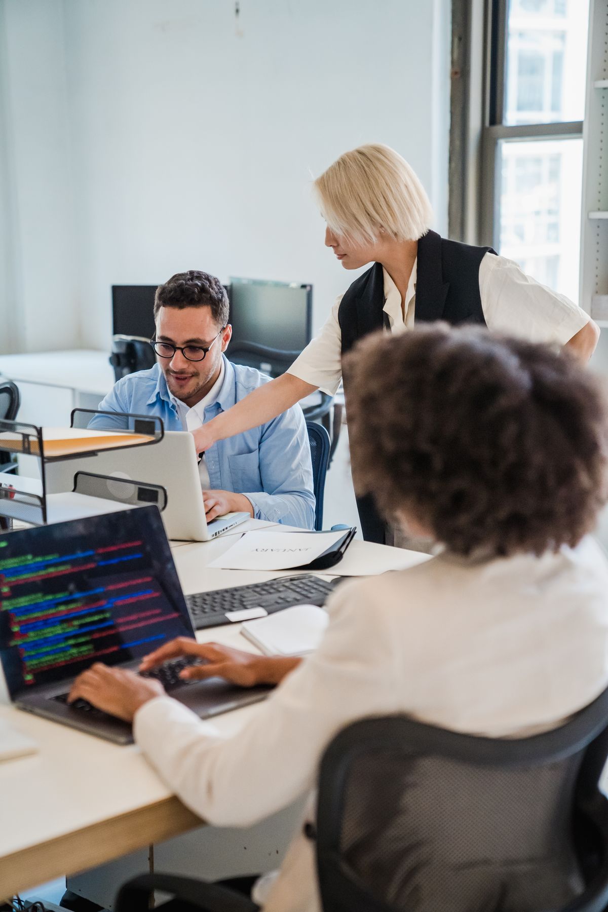 A connected product team collaborating on laptops in an office, working through a change together