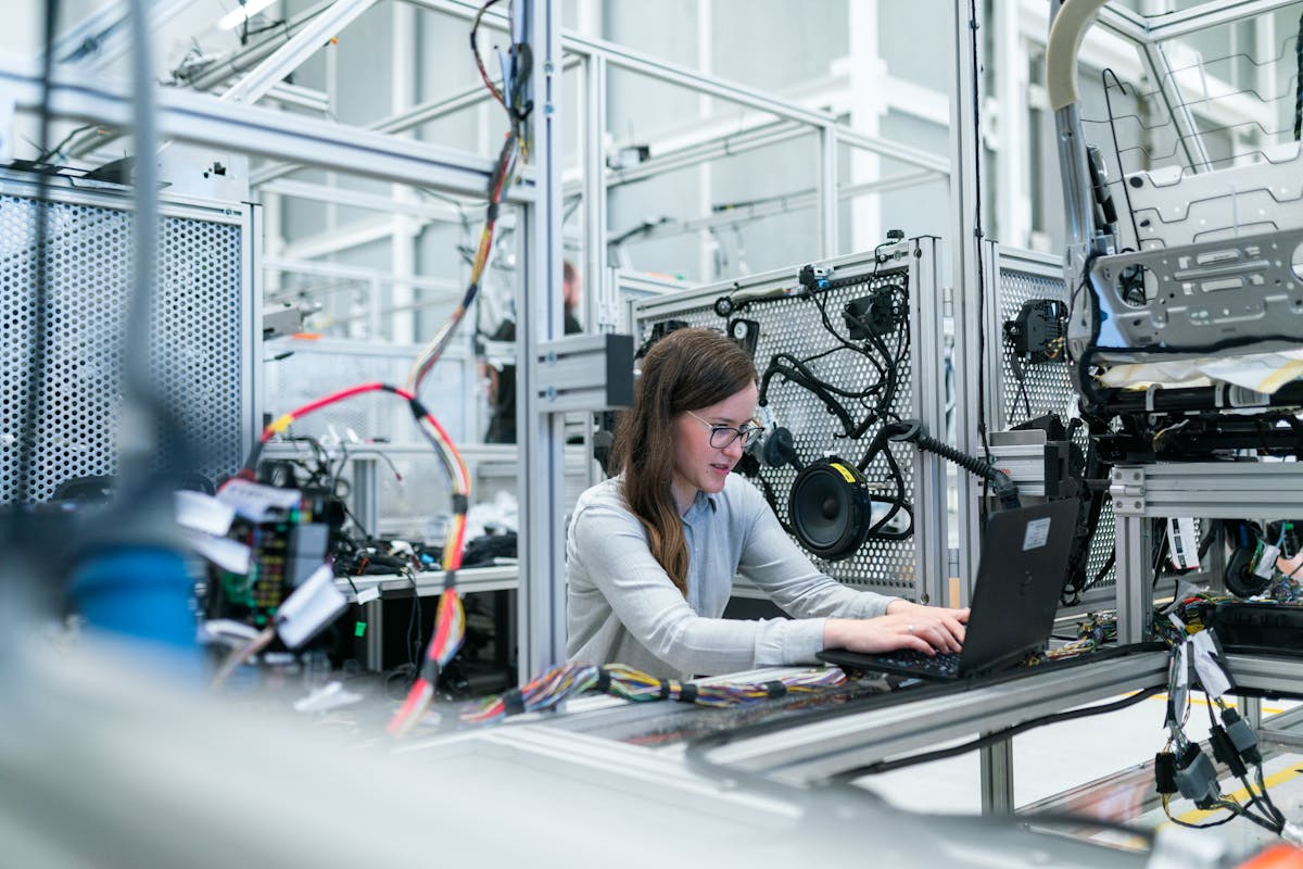 Engineer working on a laptop surrounded by electronics test equipment in a lab